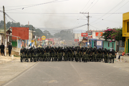 The Guatemalan army walking down a road to keep things in order.